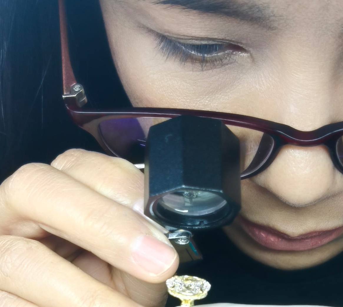 BCJExport quality controller closely inspecting a finished ring under magnification